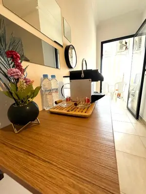 a kitchen with a counter top with a vase of flowers at Appartement au Centre ville Gueliz avec piscine in Marrakech
