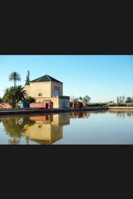 a building with a reflection in a body of water at Gorgeous newly renovated apt- Near Restaurant and Shopping Center in Marrakech