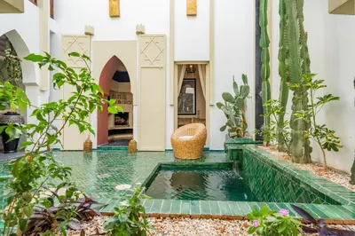 a courtyard with a pool of water in a building at Riad EYNA Marrakech Medina in Marrakech