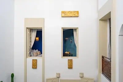 a room with three windows on the wall at Riad EYNA Marrakech Medina in Marrakech