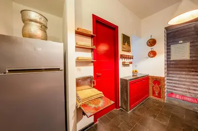 a kitchen with a red door and a red refrigerator at Riad EYNA Marrakech Medina in Marrakech