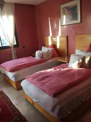 two beds in a room with red walls at Appartement Elias Marrakech in Marrakech