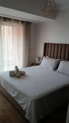 a bedroom with a large white bed with a window at Marrakech appartement babylon2 in Marrakech