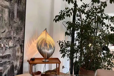 a lamp sitting on a table next to two plants at Villa d architecte Marrakech in Oulad Jellal