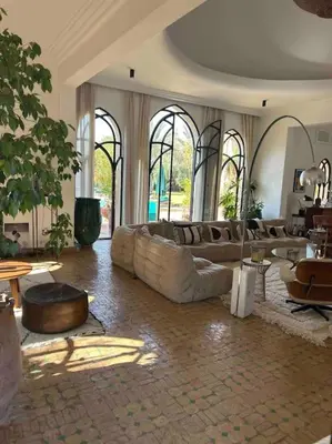 a living room with couches and tables and windows at Villa d architecte Marrakech in Oulad Jellal