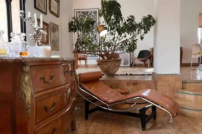 a living room with a chair and a dresser at Villa d architecte Marrakech in Oulad Jellal