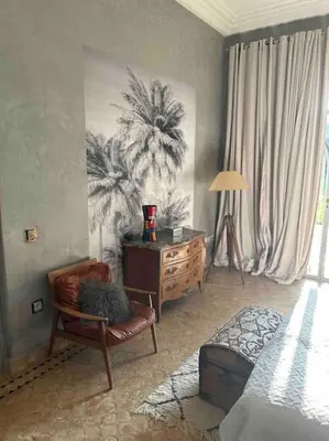 a bedroom with a chair and a dresser and a bed at Villa d architecte Marrakech in Oulad Jellal