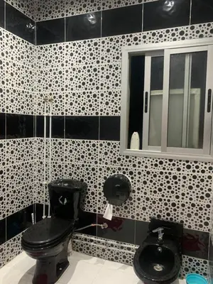 a bathroom with a black toilet and a window at The Red Flat in Marrakech