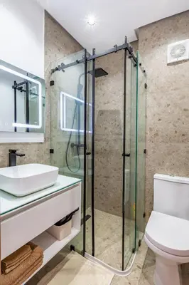 a bathroom with a glass shower and a toilet at Villa Gina, chic et Moderne avec piscine&terrasse in Marrakech