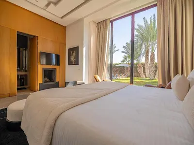 a bedroom with a large bed and a large window at Palais Noor in Douar Caïd Layadi