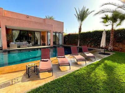 a group of chairs sitting next to a swimming pool at Palais Noor in Douar Caïd Layadi