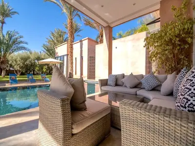 a patio with wicker furniture next to a swimming pool at Palais Noor in Douar Caïd Layadi