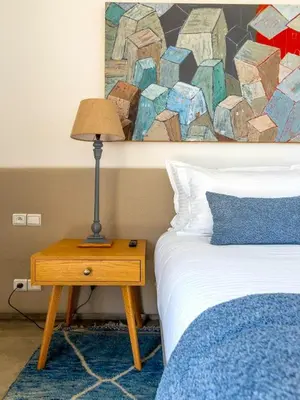 a bedroom with a bed and a table with a lamp at Palais Noor in Douar Caïd Layadi