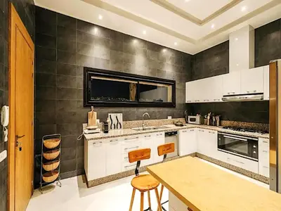a kitchen with white cabinets and a wooden table at Palais Noor in Douar Caïd Layadi