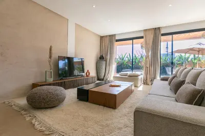 a living room with a couch and a tv at Dar Al Ikhwa, Lodge de luxe à Marrakech in Sfiani