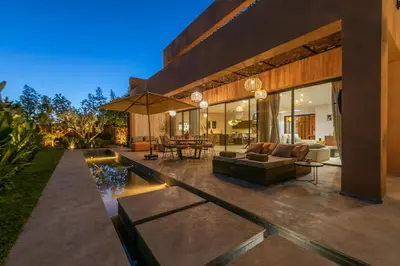 a house with a patio with a couch and a table at Dar Al Ikhwa, Lodge de luxe à Marrakech in Sfiani