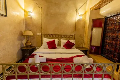a bedroom with a bed with red pillows at Riad Sarasvati & SPA in Marrakech