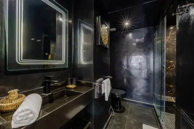 a black bathroom with a sink and a shower at Luxury 2-Bedroom Apartment in Hivernage Pool Residence Near Casino in Marrakech