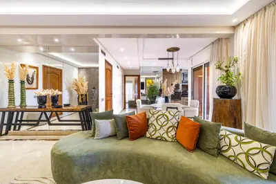 a living room with a green couch with colorful pillows at Luxury 2-Bedroom Apartment in Hivernage Pool Residence Near Casino in Marrakech