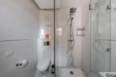 a white bathroom with a shower and a toilet at Luxury Apartment in Marrakech in Marrakech