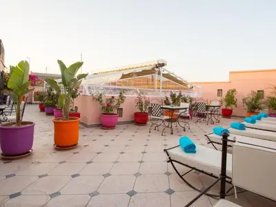 a patio with tables and chairs and potted plants at Riad Magda & Spa in Marrakech