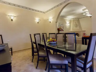 a dining room with a table with chairs and a bowl of fruit at Riad Magda & Spa in Marrakech