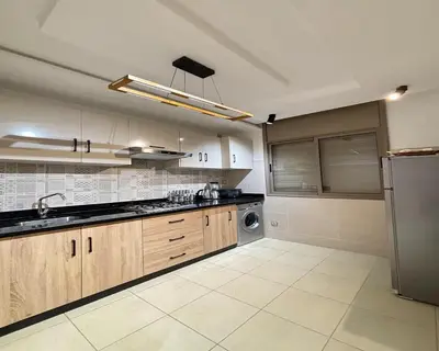 a kitchen with wooden cabinets and a stainless steel refrigerator at Retraite paisible à Gueliz in Marrakech