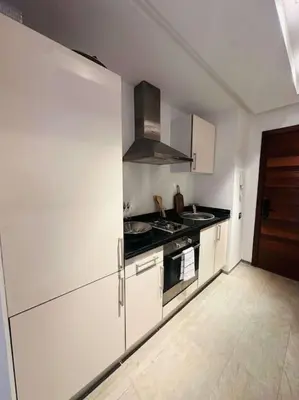 a kitchen with white cabinets and a stove top oven at Luxueux 1 Chambre Guéliz Centre in Marrakech