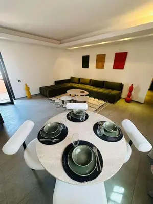 a living room with a table and chairs and a couch at Luxueux 1 Chambre Guéliz Centre in Marrakech
