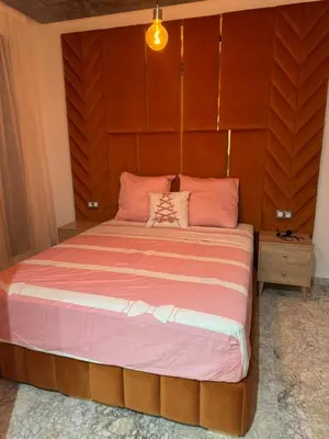 a bedroom with a large bed with a wooden headboard at Luxueux Appartement-52 - Guéliz Marrakech in Marrakech