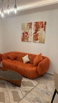 a brown couch in a living room with pictures on the wall at Luxueux Appartement-52 - Guéliz Marrakech in Marrakech
