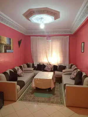 a living room with a couch and a table at Superbe Appartement 2 chambres à AL FADL Marrakech in Marrakech