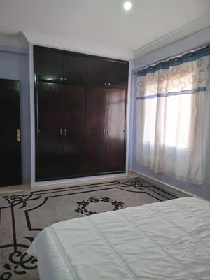 a bedroom with a bed and a large window at Superbe Appartement 2 chambres à AL FADL Marrakech in Marrakech