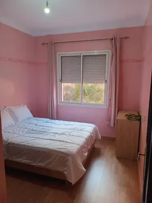 a pink bedroom with a bed and a window at Superbe Appartement 2 chambres à AL FADL Marrakech in Marrakech
