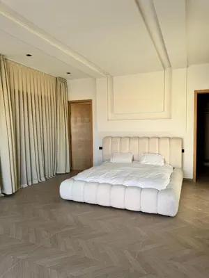 a bedroom with a large white bed with white pillows at Villa Chafti in Douar Khalifa Ben Mbarek