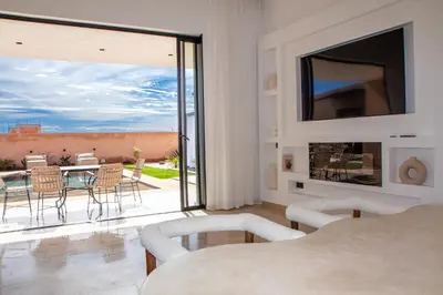 a living room with a view of a patio at Villa Chafti in Douar Khalifa Ben Mbarek