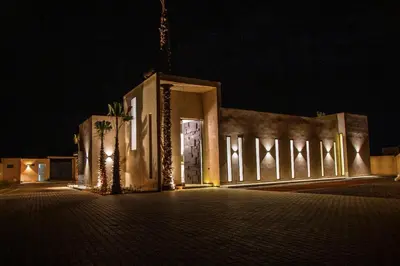 a building lit up at night with lights at Villa Chafti in Douar Khalifa Ben Mbarek