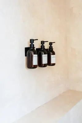 three bottles of soap are hanging on a wall at Merveille d'Art & Design - Marrakech Downtown in Marrakech