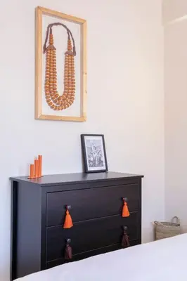 a black dresser in a bedroom with a picture on the wall at Merveille d'Art & Design - Marrakech Downtown in Marrakech