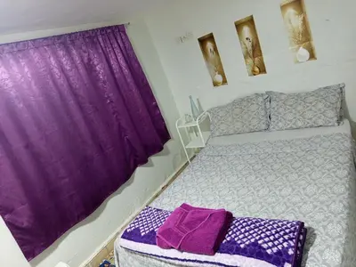a bedroom with a purple curtain and a bed at Riad Derb El Aarsa in Marrakech