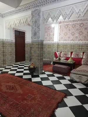 a living room with a couch and a checkered floor at Riad Derb El Aarsa in Marrakech