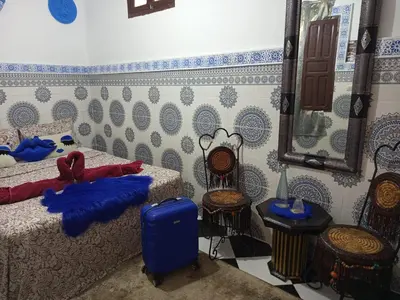 a bedroom with two beds and a mirror and chairs at Riad Derb El Aarsa in Marrakech