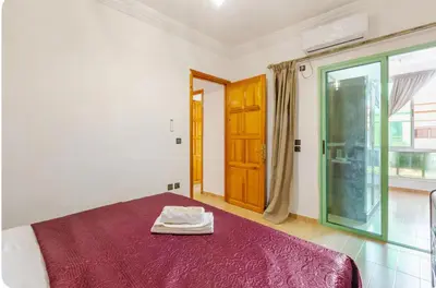a bedroom with a bed with a red blanket and a window at Charming Two-Bedroom Apartment in Gueliz,Marrakesh in Marrakech