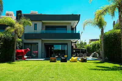 a house with a yard with palm trees at Villa de luxe Avec piscine à Argan Golf Resort in Marrakech
