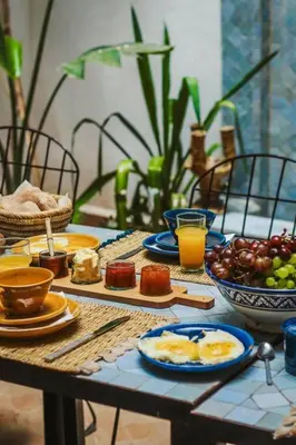 a wooden table with breakfast foods and drinks on it at RIAD Dar Argana 100m Place Jemaa el- Fna heated Pool in Marrakech