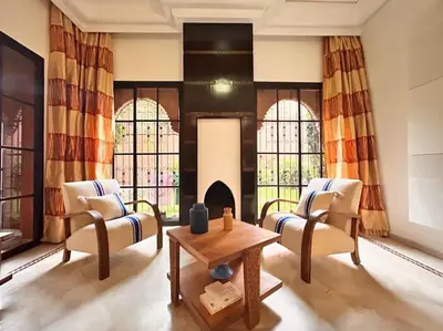 a living room with two chairs and a table and a fireplace at Villa Gioia et Luna Garden City-Services All-inConciergerie in Marrakech