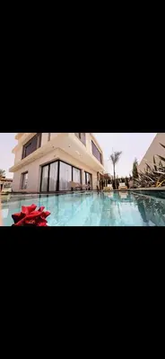 a building with a swimming pool in front of it at Luxe villa in marrakech in El Makina