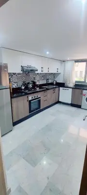 a large kitchen with a white floor and appliances at Elégant duplex au coeur de Marrakech, Nakhil in Marrakech