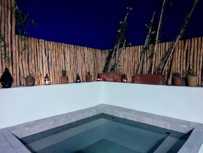 a swimming pool in front of a wooden fence at Riad LISA 6 personnes in Marrakech