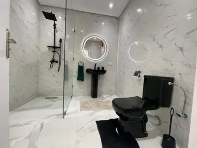 a bathroom with a toilet and a glass shower at Centre de Guéliz in Marrakech